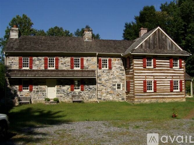 A house with a stone foundation and a wooden exterior is shown.