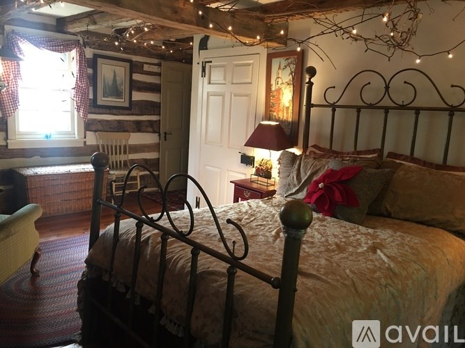 A bedroom with a bed, a chair, and a window.