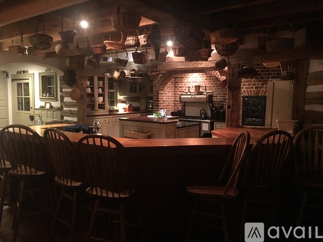 A kitchen with a table and chairs in front of a brick wall.