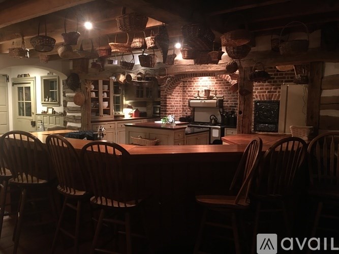 A kitchen with a table and chairs in front of a brick wall.