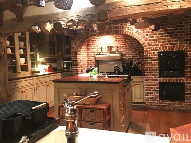 A kitchen with a brick wall and wooden cabinets.