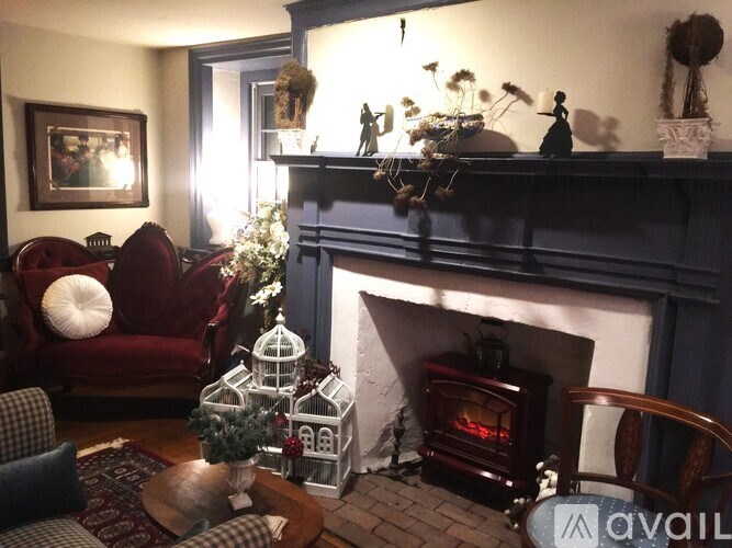 A living room with a fireplace and a Christmas tree.