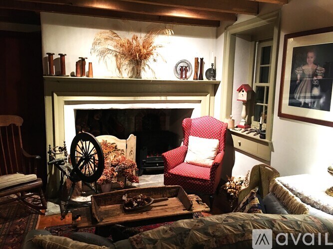 A cozy room with a fireplace and a red chair.