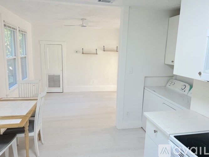 A tree-lined street with cars parked on the side.