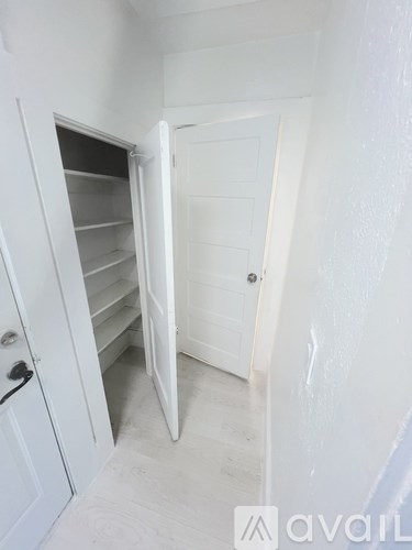 A kitchen with white appliances and cabinets is available for rent.