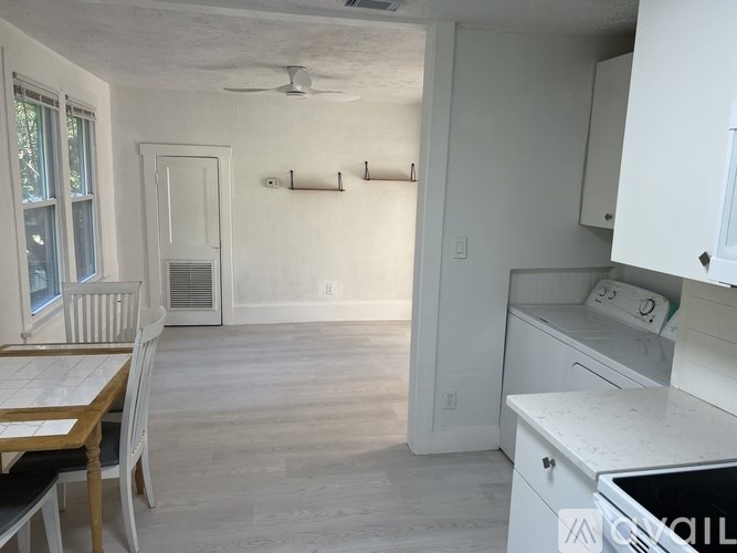 A kitchen with white cabinets and a wooden table.