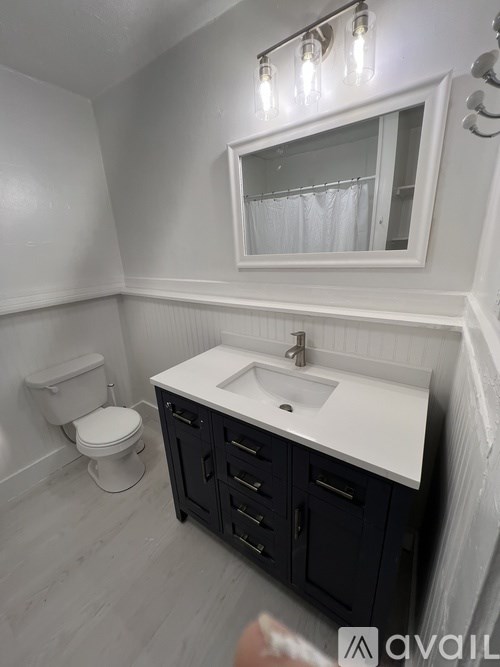 A bathroom with a white sink and a white toilet.