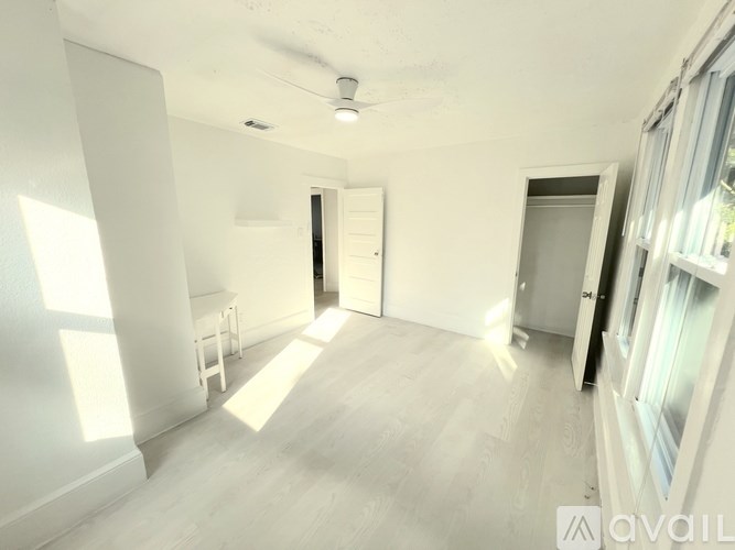 A white refrigerator is open in a narrow hallway.