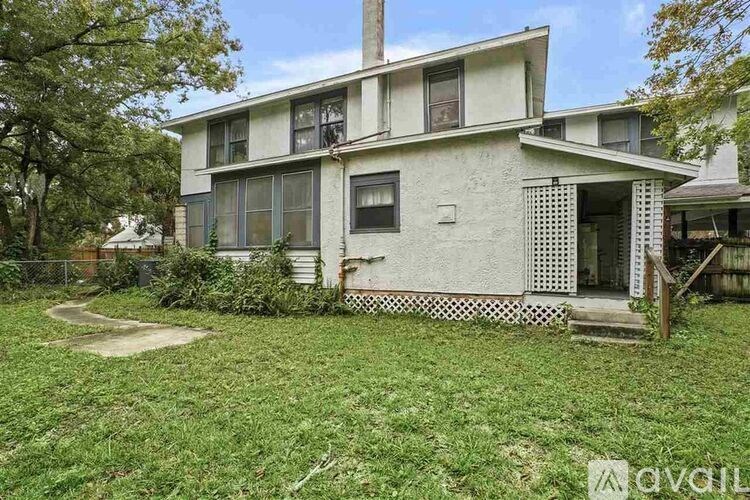 A white house with a green lawn in front.