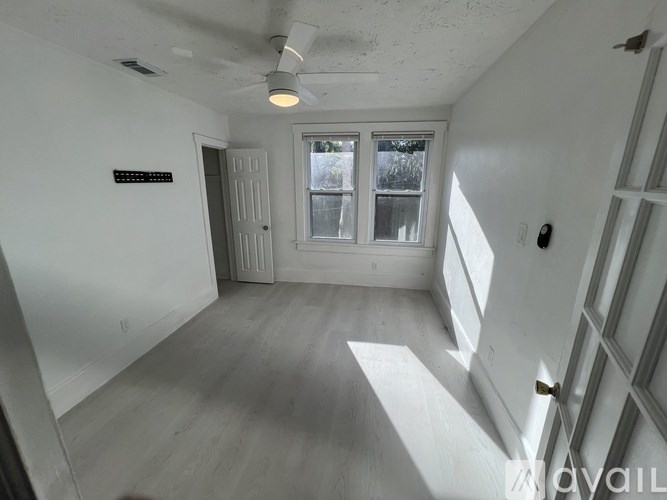 A room with a ceiling fan and a window.