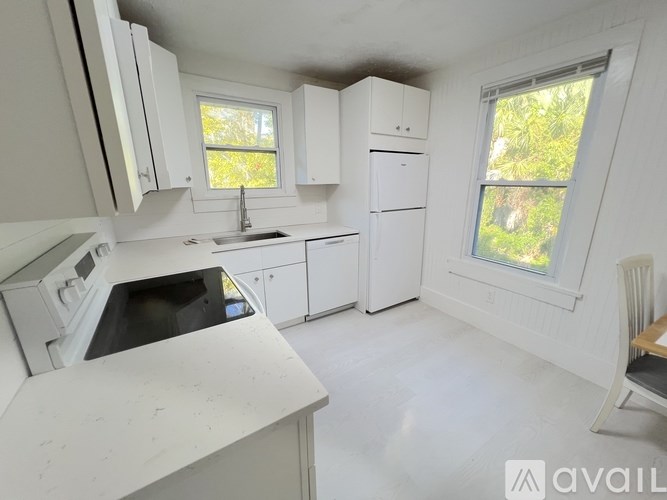 A hallway with a door on the left and a window on the right.