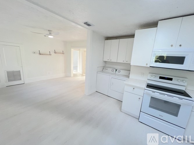 A house with a lawn and a tree in front of it.