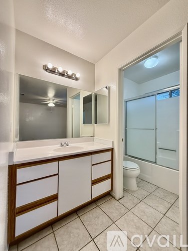 A bathroom with a sink, mirror, and toilet.
