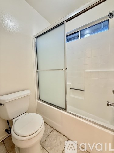 A white toilet in a bathroom with a glass shower door.