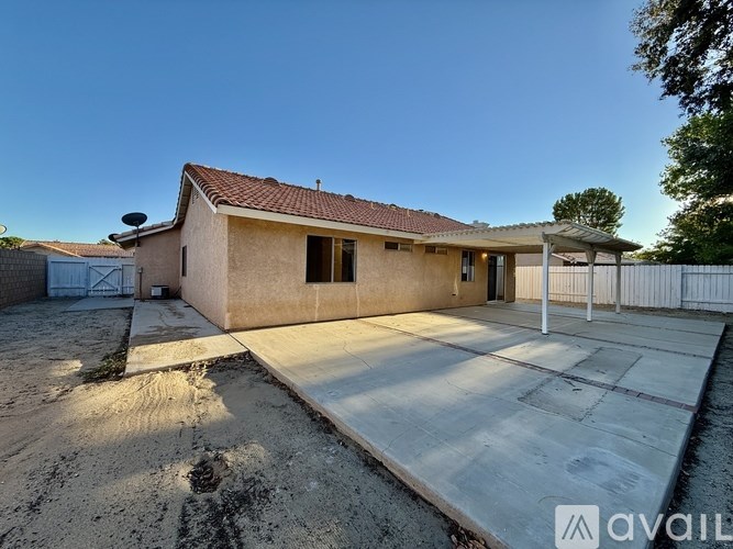 A house with a red roof and a white fence is available for sale.