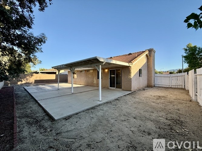 A house with a brown roof and a white fence is shown.