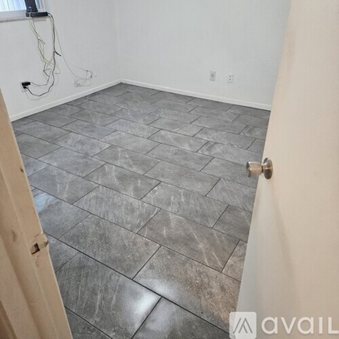 A room with a tiled floor and a door on the left.