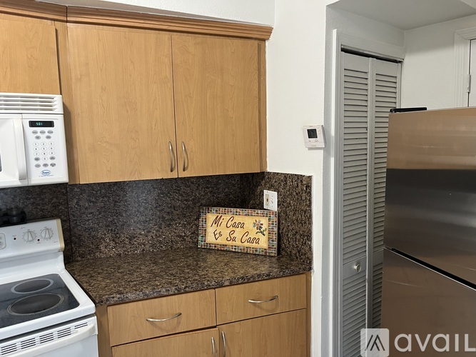 A kitchen with wooden cabinets and a white stove top oven.