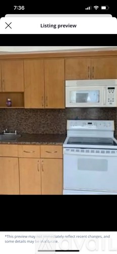 A kitchen with wooden cabinets and a white stove top oven.