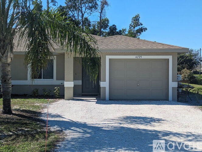 A two-story house with a garage door and a driveway.