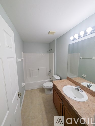 A bathroom with a toilet, sink, and mirror.