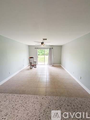 A room with a chair and a fan.