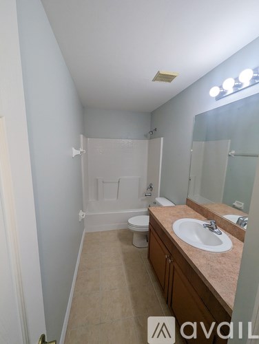 A bathroom with a toilet, sink, and mirror.