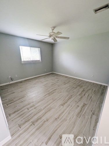 A room with a ceiling fan and a window.
