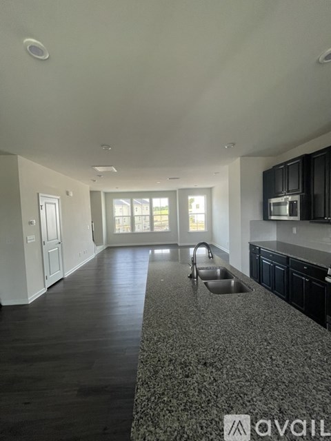 A kitchen with black cabinets and a granite countertop.