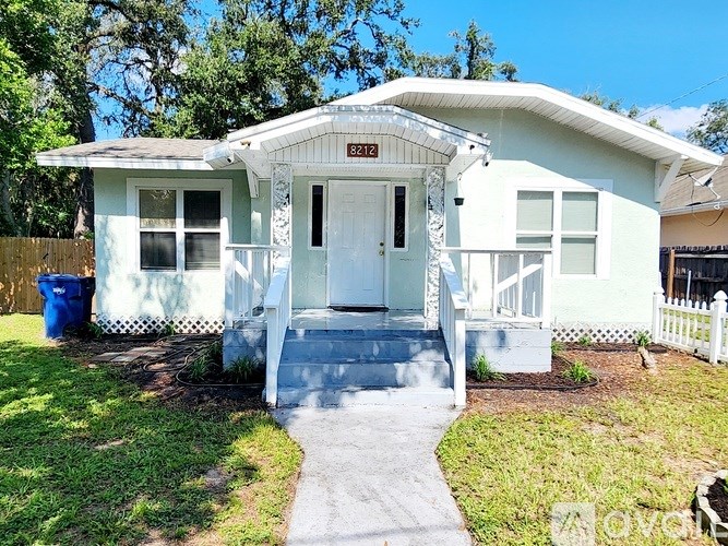A white house with the number 8212 on the front door.