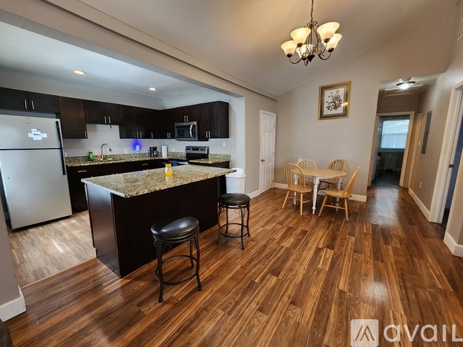 A kitchen with a marble countertop and wooden floors.