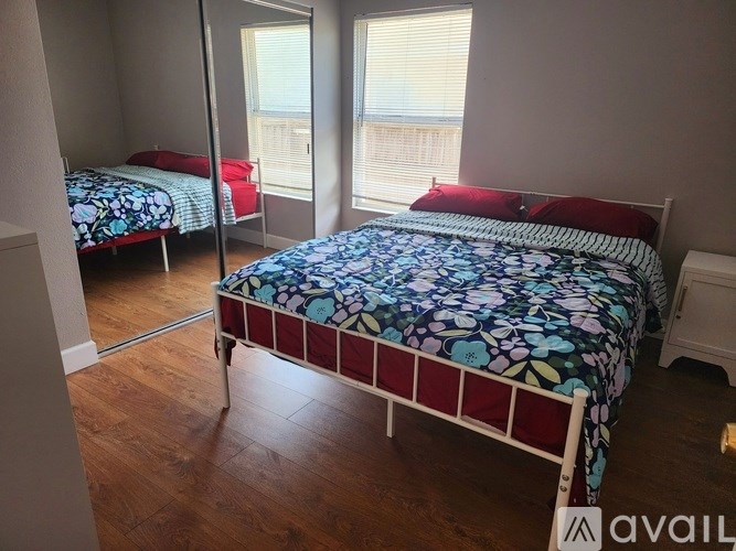 A bedroom with a large bed and a smaller bed in the background.