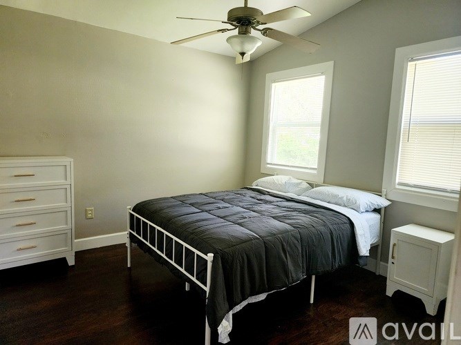 A bedroom with a bed, dresser, and window.