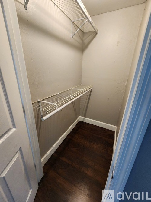 A small, empty room with a white door and a shelf.