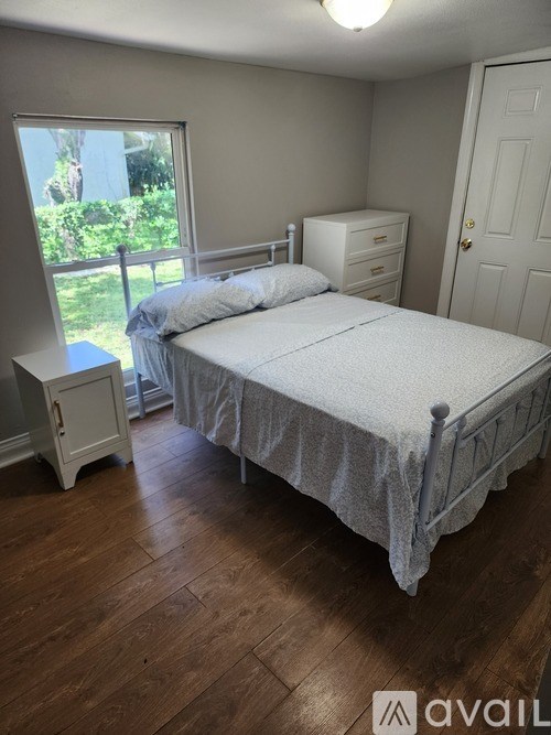 A bedroom with a bed, nightstand, and dresser.
