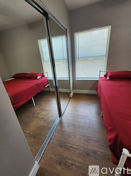 A bedroom with two beds and a sliding glass door.