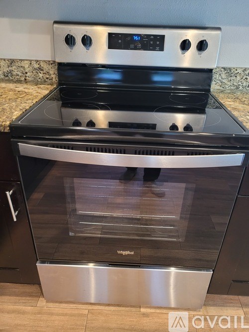 A modern stainless steel oven with a digital control panel and a glass door.