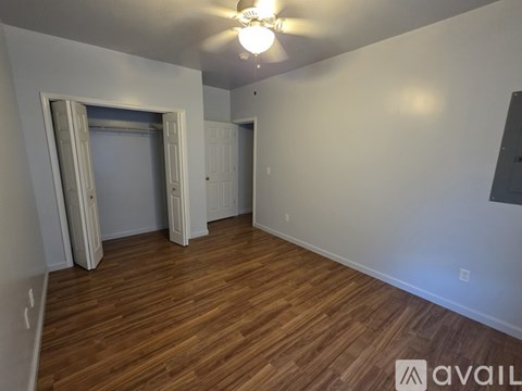 A room with wooden floors and a ceiling fan.