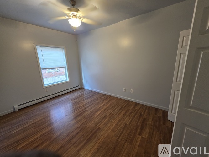 A room with wooden floors and a ceiling fan.