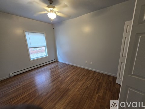 A room with wooden floors and a ceiling fan.