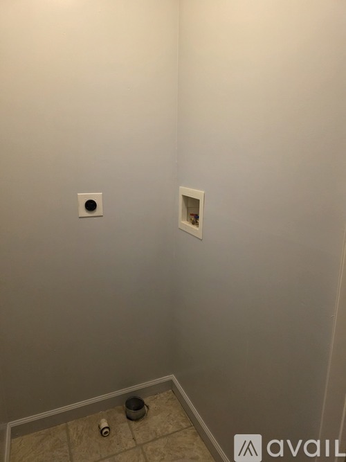 A bathroom with a toilet paper holder and a toilet brush.