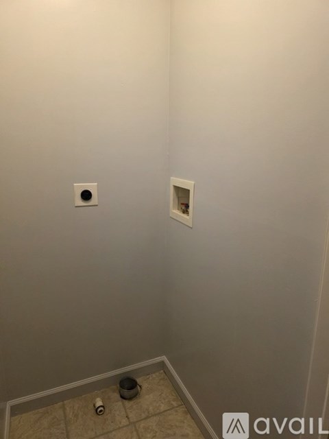 A bathroom with a toilet paper holder and a toilet brush.