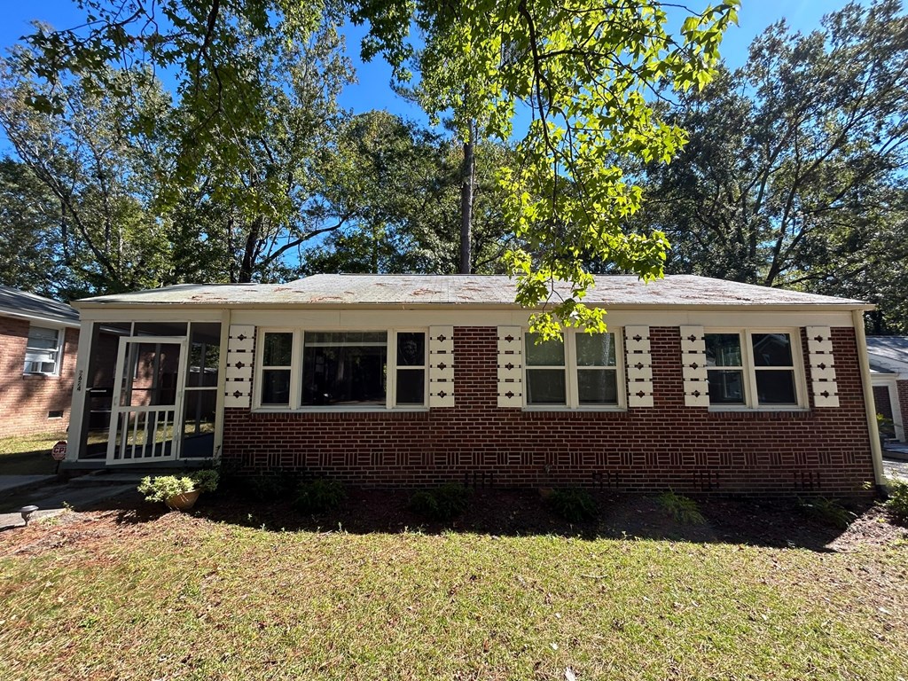 A small house with a red brick exterior and white trim.