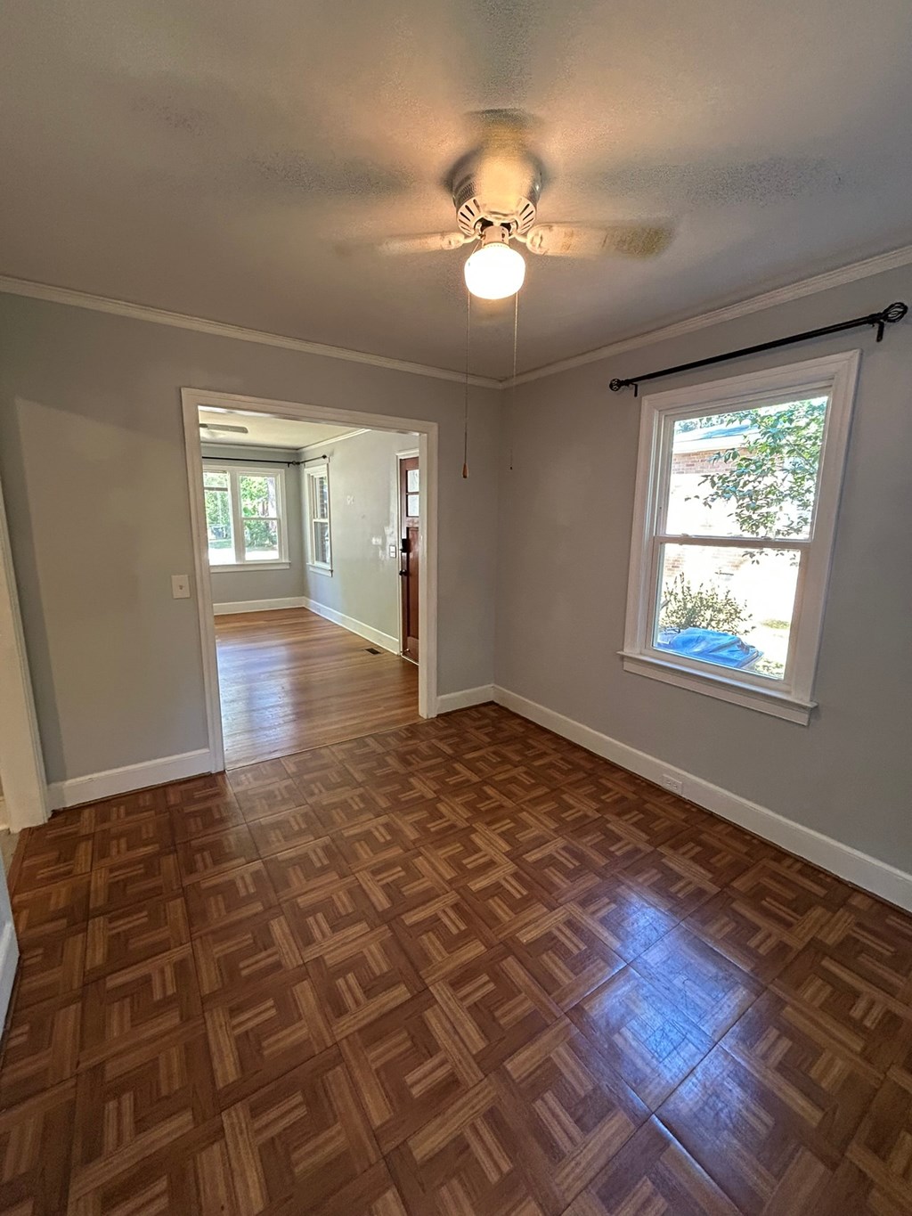 A room with a wooden floor and a ceiling fan.