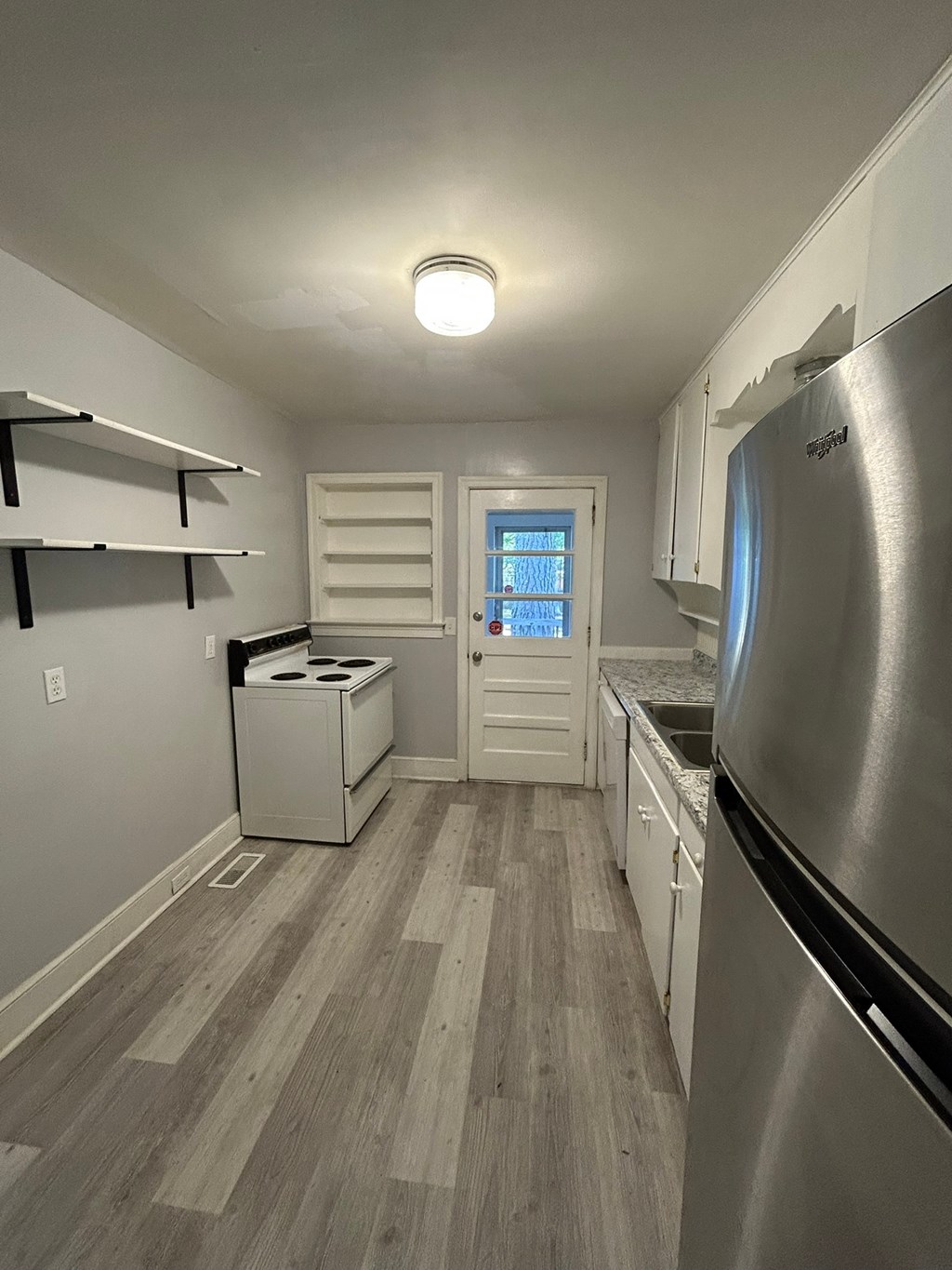A kitchen with a stainless steel refrigerator and a dishwasher.