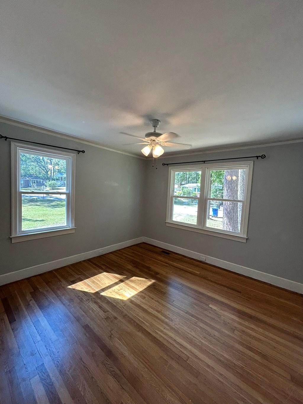 A room with wooden floors and a ceiling fan.