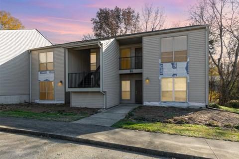 A two-story apartment building with a balcony on the second floor.