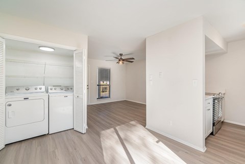 A white kitchen with a washer and dryer in it.