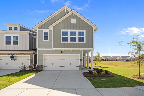 A two-story house with a garage and a driveway.