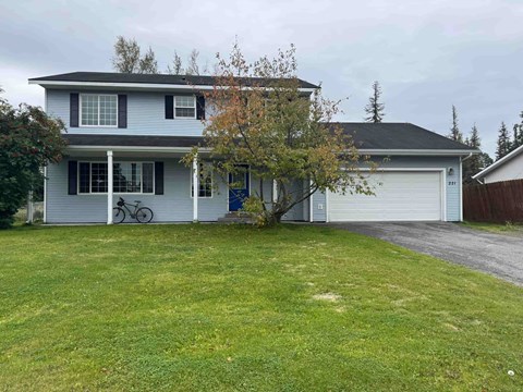 A house with a grey roof and a white garage door.